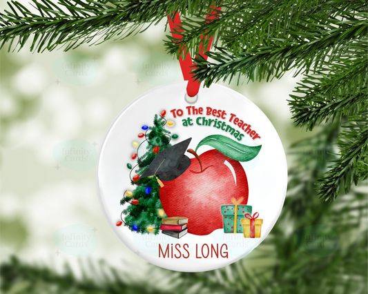 Christmas ornament with a red apple, tree, and books on a white background, hanging from a tree.