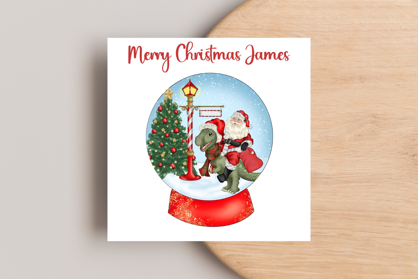 Santa riding a Dinosaur in a Snow Globe Christmas Card- Personalised