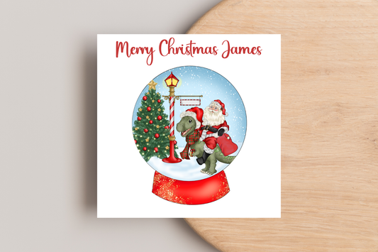 Santa riding a Dinosaur in a Snow Globe Christmas Card- Personalised