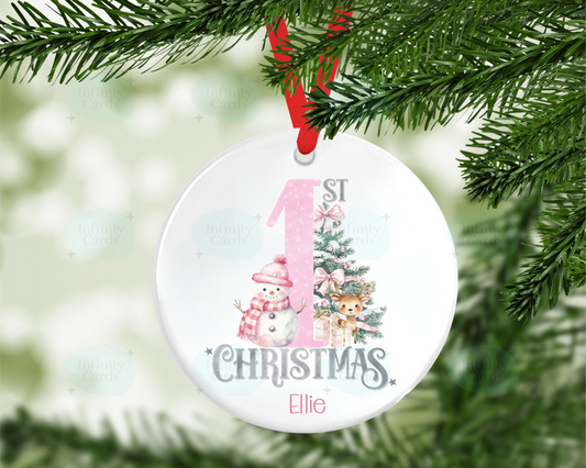 Christmas ornament with '1st Christmas' text and tree design, hanging on a tree.
