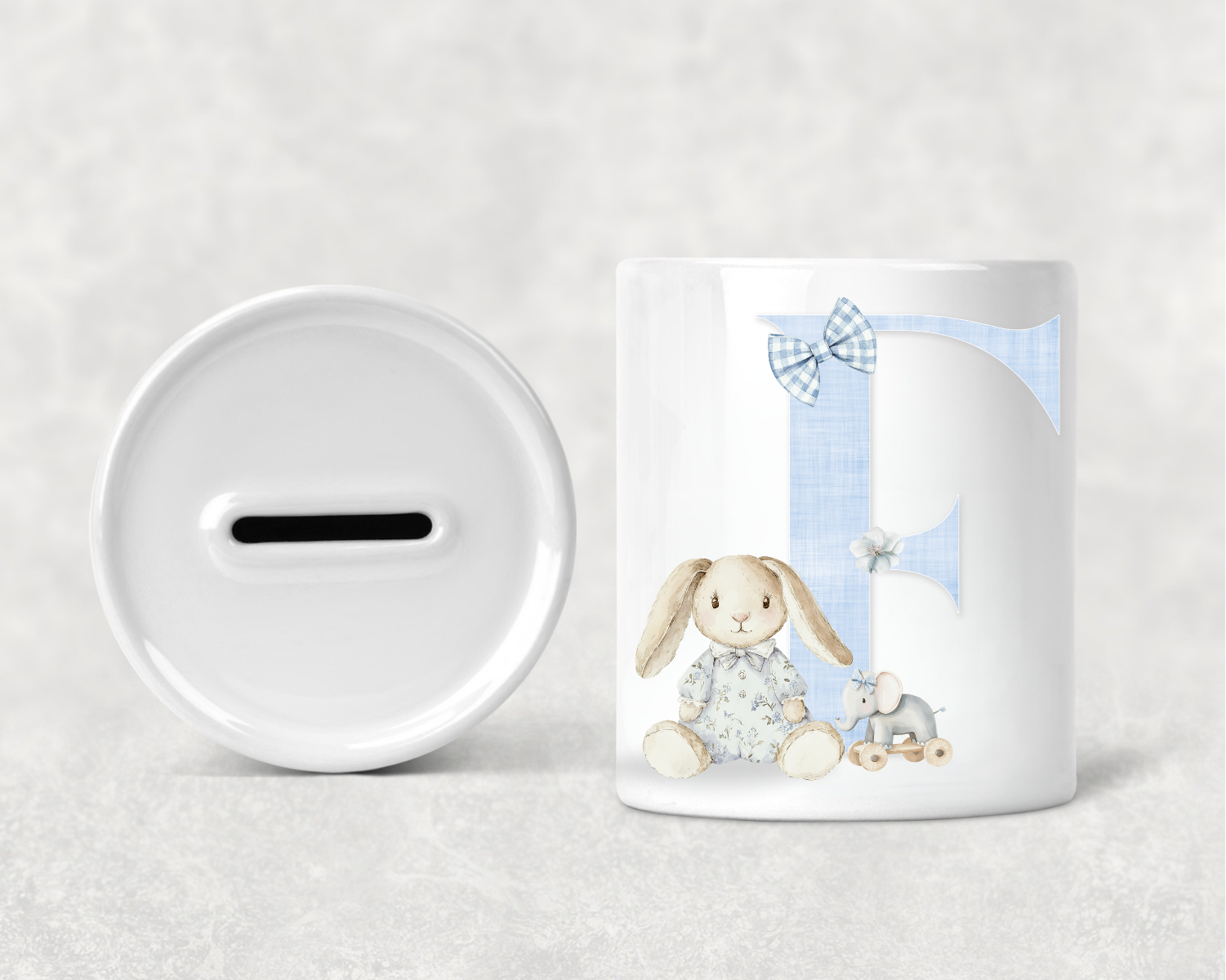 White mug with a rabbit design and a white piggy bank on a light gray background